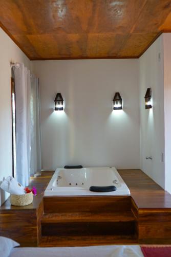 a bath tub in a room with two lights at Casa do velejador in Barra Grande