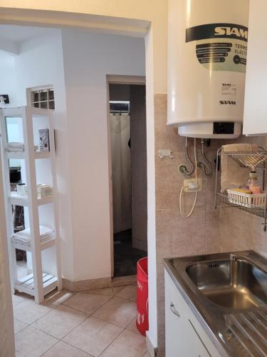 a kitchen with a sink and a door to a room at Departamento A&F I planta baja in San Fernando del Valle de Catamarca