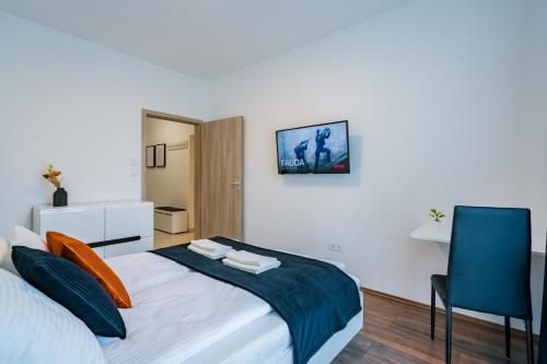 ein Schlafzimmer mit einem Bett und einem blauen Stuhl in der Unterkunft Fox Premium Apartment & Free Private Parking in Budapest