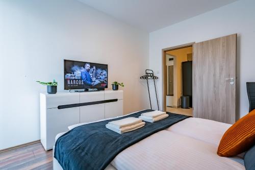 Schlafzimmer mit einem TV auf dem Bett in der Unterkunft Fox Premium Apartment & Free Private Parking in Budapest