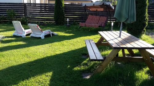 a picnic table and two chairs and an umbrella at Forest Edge Lodge in Rīga