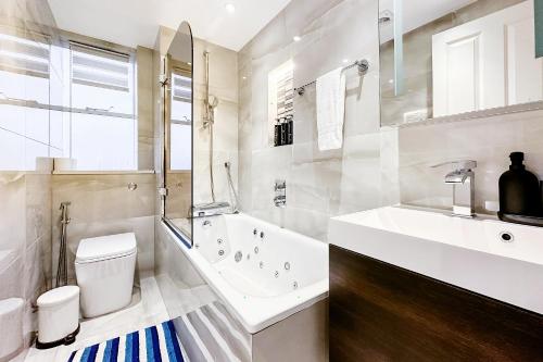 La salle de bains est pourvue d'une baignoire, de toilettes et d'un lavabo. dans l'établissement Luxury 3 Bedrooms Apartment in Central London, à Londres