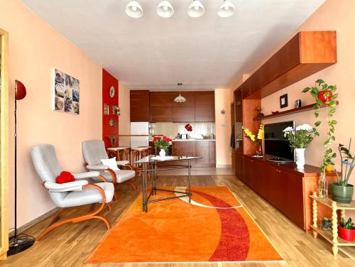 a living room with a table and chairs and a kitchen at Lovely home - Free parking in Budapest