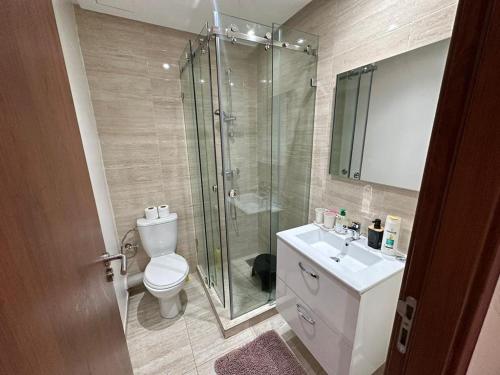 a bathroom with a shower and a toilet and a sink at Prestigia appartement de lux in Marrakesh