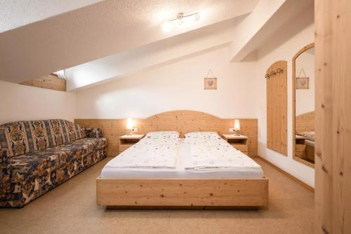 1 dormitorio pequeño con 1 cama y 1 sofá en Appartement Anton, en Sand in Taufers