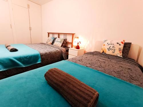a bedroom with two beds with blue sheets at By Plaza Real Rooms in Barcelona