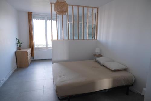 une chambre avec un lit dans une pièce avec une fenêtre dans l'établissement Grand appartement 80m² - Suite parentale, à Villeurbanne