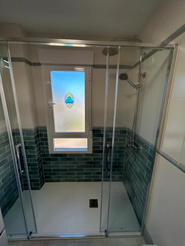 uma casa de banho com um chuveiro e uma janela em VUT EL PARQUE PISO 3DORMITORIOS Y 2 BAÑOS CON PISCINA EN VERANO. em Ciudad Real