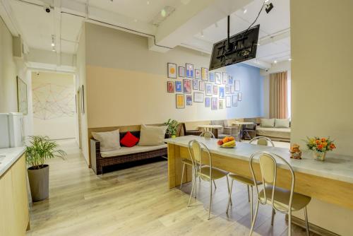 Bodo Hostel في بيشكيك: مطبخ وغرفة معيشة مع طاولة وكراسي