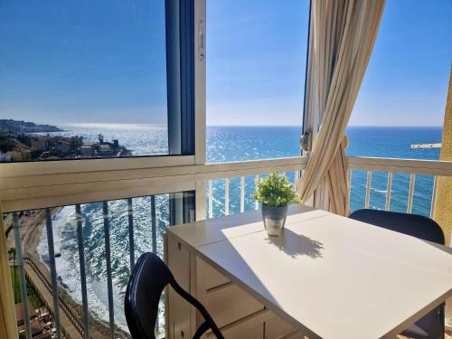 una mesa blanca con una planta en un balcón con vistas al océano en SR Almirante 1ª Linea de Playa, en Mijas Costa