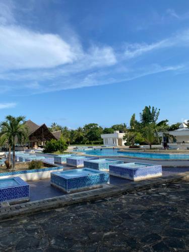 um grupo de bancos azuis em frente a uma piscina em Cozy beachfront studio em Diani Beach