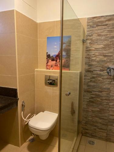 uma casa de banho com um WC e um chuveiro com uma fotografia em Cozy beachfront studio em Diani Beach