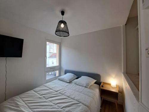 - une chambre avec un lit, une télévision et une lampe dans l'établissement Bologne, studio climatisé, à Reims