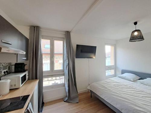 - une chambre avec un lit, un four micro-ondes et une fenêtre dans l'établissement Bologne, studio climatisé, à Reims