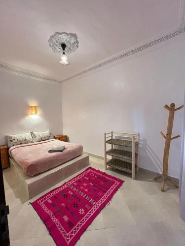 Schlafzimmer mit einem Bett und einem roten Teppich in der Unterkunft Appartement In Ksar Ait Ben Haddou in Aït-Ben-Haddou
