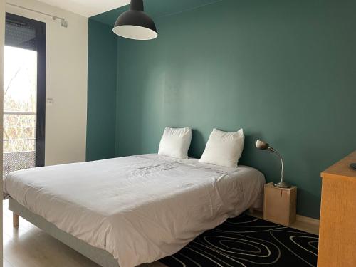 1 dormitorio con cama blanca y pared azul en Pasteur, en Troyes