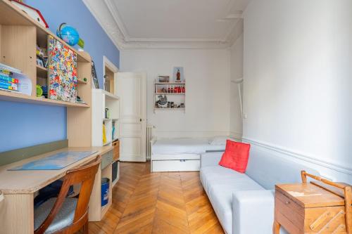 un salon avec un canapé et un bureau dans l'établissement Veeve - The Artist's Residence, à Paris