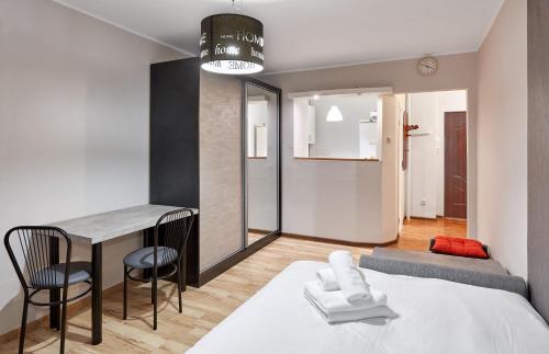 1 dormitorio con cama, mesa y escritorio en Pod Lipami Standard Studio, en Poznan
