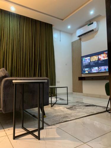 een woonkamer met een tv en een bank en een tafel bij Luxury apartments in Ibadan