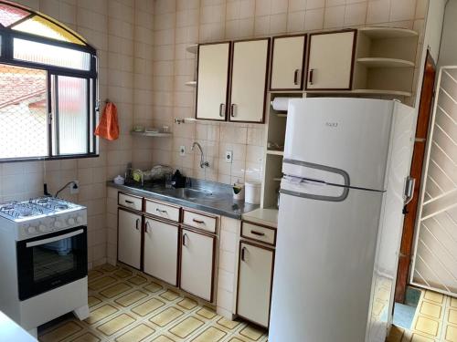 a kitchen with a refrigerator and a sink at Quartos em casa no Clelia Bernardes in Viçosa