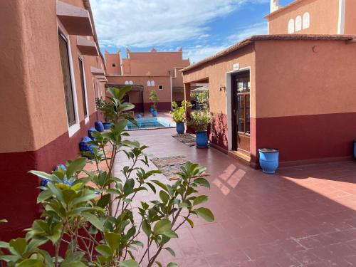 einen Innenhof eines Gebäudes mit Topfpflanzen in der Unterkunft Appartement In Ksar Ait Ben Haddou in Aït-Ben-Haddou