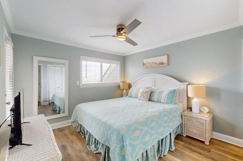 a bedroom with a bed and a ceiling fan at CAB03 Pelicans Penthouse in Oak Island