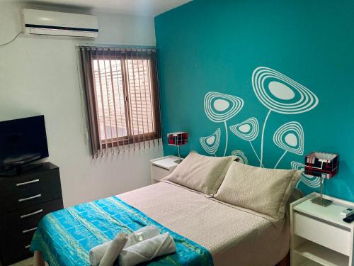 1 dormitorio con cama y pared azul en Departamento Ludmila en Villa María
