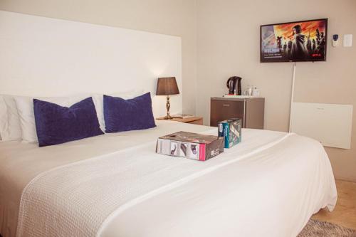 a white bed with a box on top of it at Amabwe Guesthouse in Grahamstown