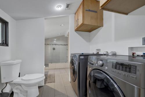 a bathroom with a washing machine and a toilet at 406 Lodge-A: Hot-Tub & 2 Blks to Main St in Fredericksburg
