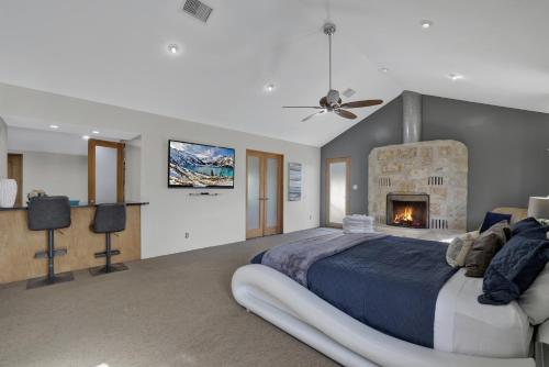 a bedroom with a large bed and a fireplace at 406 Lodge-A: Hot-Tub & 2 Blks to Main St in Fredericksburg