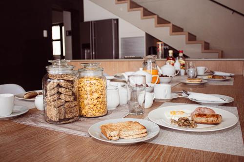 a table with plates of food and jars of nuts at Amabwe Guesthouse in Grahamstown