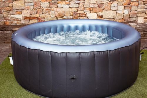 a large hot tub in front of a brick wall at Amabwe Guesthouse in Grahamstown