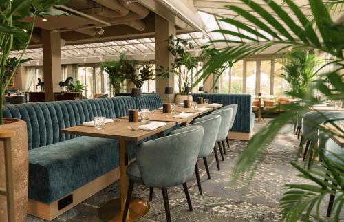 een restaurant met een lange tafel en stoelen bij Carlton Oasis Hotel in Spijkenisse