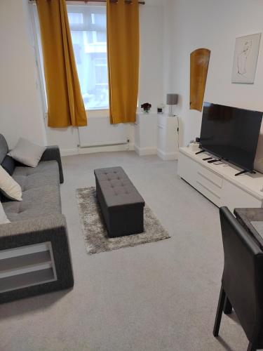 a living room with a couch and a tv at Modern 2 bed house sleeps 6 in Portsmouth