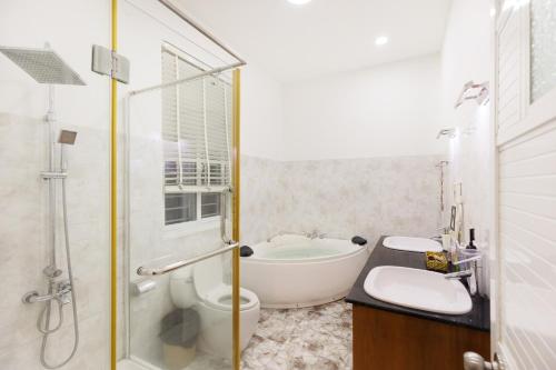 a bathroom with a tub and a toilet and a sink at Nha Trang Riverside Villa in Nha Trang