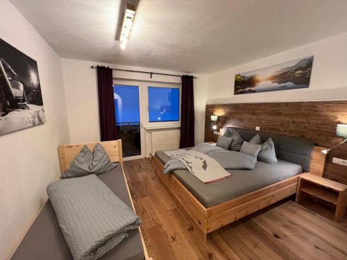 ein kleines Schlafzimmer mit einem Bett und einem Fenster in der Unterkunft Berghof Haselsberger Appartements in Sankt Johann in Tirol