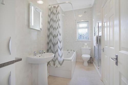 a white bathroom with a sink and a toilet at Falmer Serene Getaway, Newly Refurbished, Sleeps 4 in Darlington