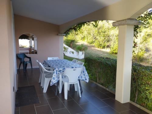 Zimmer mit einem Tisch und Stühlen auf einer Terrasse in der Unterkunft Villa Lolotha in La Caletta