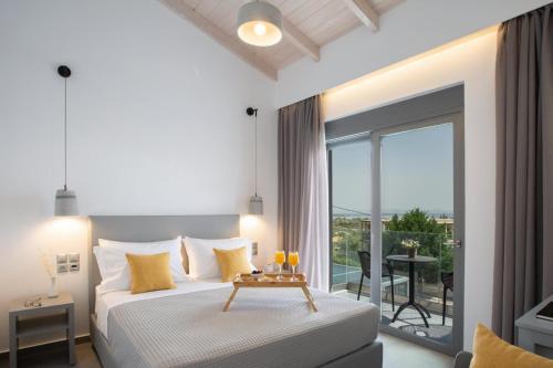 a white bedroom with a bed and a balcony at Aloft Luxury Villas with heated pool and sea view in Apolpaina