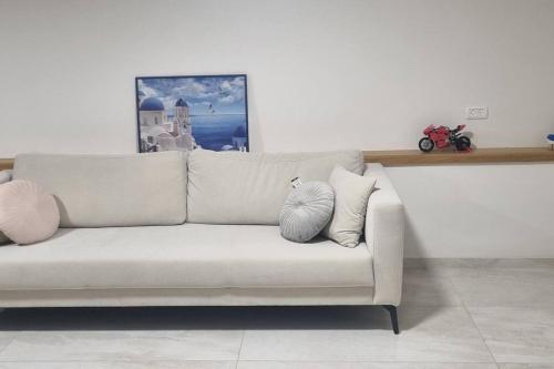 un sofá blanco sentado en una sala de estar en studio apartment, en Naẕerat ‘Illit