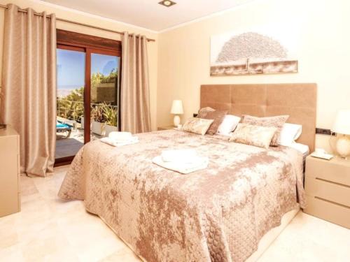 a bedroom with a large bed and a balcony at Casa Orquídea in Jávea