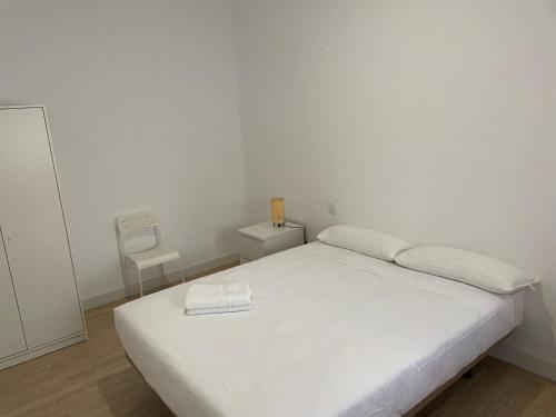 um quarto com uma cama branca com um livro em U4 Apartamento a estrenar, centro Madrid em Madrid