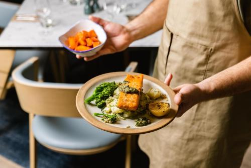 Een man met een kom eten in zijn handen. bij Leonardo Hotel Leeds in Leeds