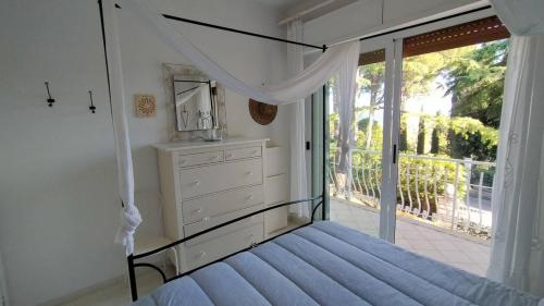 a bedroom with a canopy bed and a balcony at Villa Girasoli - Taunus Vacanze in Numana