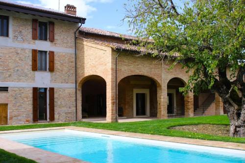 an empty swimming pool in front of a building at Villa Finetta - Tabiano Castello Country Villas in Salsomaggiore Terme