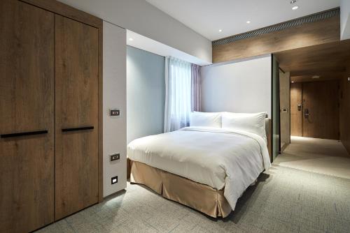 a bedroom with a large bed and a closet at K Hotel Taipei Nanjing in Taipei