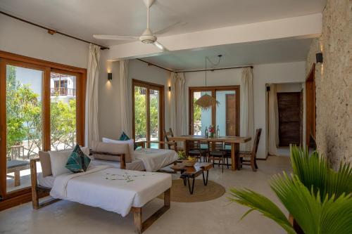 a living room with a bed and a dining room at Natural Park Villa Resort in Pingwe