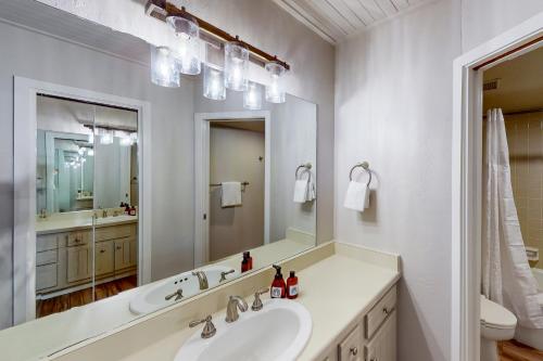 a white bathroom with a sink and a mirror at Dulany at the Gondola in Steamboat Springs
