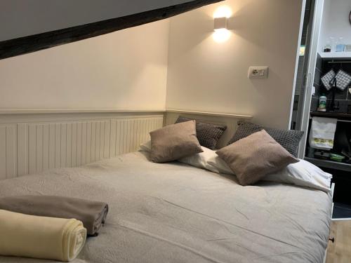 a bed with two pillows on it in a room at La Piccola Mole - Turin Cozy Apartment in Turin