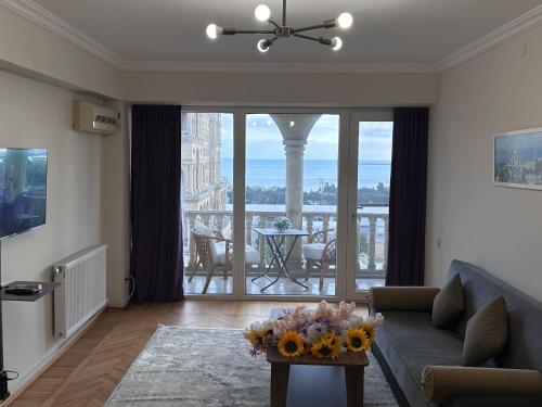 ein Wohnzimmer mit einem Sofa und einem Tisch mit Blumen darauf in der Unterkunft Sea view Residence in Baku